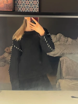 Svart stickad tröja  - Säljer min svarta stickade tröja men vita detaljer. Har knappt använt den.