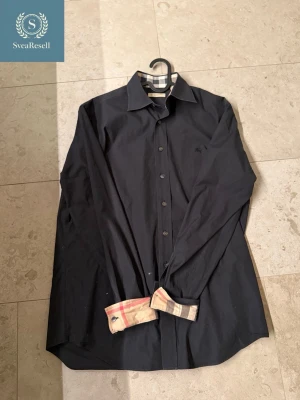 Mörkblå Burberry skjorta  - Säljer en Mörkblå Burberry skjorta. Perfekt för sena sommar kvällar 🌃                                 •Storlek: S/M                                                            •Färg: Mörkblå🍾                                                 •Märke: Burberry💸                                                  •Skick: 8/10                                                            Skriv privat om du undrar något✅