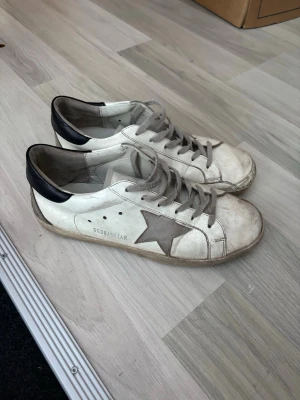 Golden Goose skor  - Golden Goose Superstar skor, storlek 41 kan passa 42 med, ganska slitna då det är använda ganska mycket men går helt klart att använda utan problem, skick 6/10 där av det låga priset, väldigt bra pris för ett par äkta golden goose, hör av dig vid minsta fundering //Noel 