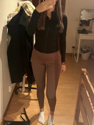 Bruna höga leggings  - Säljer ett par ljuslila/bruna leggings med hög midja och tight passform. Knappt använda! Pris kan diskuteras.