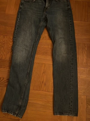 Blå jeans New Classic W29 L32 - Säljer ett par klassiska blå jeans från New Classic i storlek W29 L32. Jeansen har rak passform, fem fickor och snyggt tvättad denim med lite slitningar. Perfekta för dig som gillar en tidlös look och vill ha ett par jeans som funkar till allt.