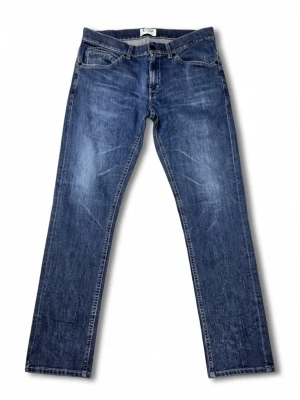 Dondup Jeans  - Snygga blå jeans från Dondup med klassisk femficksdesign och raka ben. Jeansen har en mellanblå tvätt med subtila slitningar och kontrastsömmar. Perfekta för dig som gillar en tidlös och clean look.