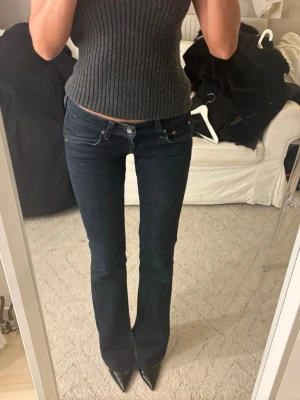 Lee Jeans - Säljer nu dessa assnygga lee jeans i perfekt marinblå nyans! De är utsvängda med slits. Jag är 169, midjemåttet är 37 cm rakt över L33