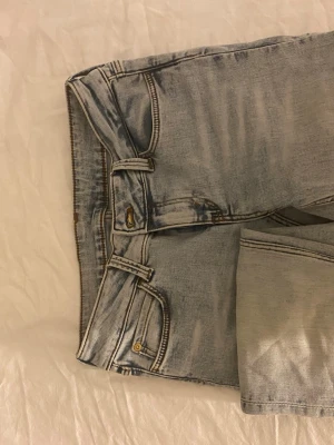 Ljusblå jeans med grön lapp - Säljer ett par ljusblå jeans från Weekday med en grön tag på baksidan. Använda ett antal gånger, men väldigt bra skick. 