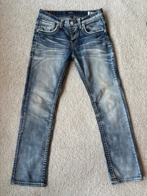 Vintage smog jeans - Tjena! Säljer mina vintage smog jeans i en otroligt snygg tvätt för en fin vintage look. Brallorna är i nytt skick och inga defekter, dem har en regular fit passform som är otroligt skön på benen. Vid fler frågor är de bara att skriva🪐💫 strl W31/L30 