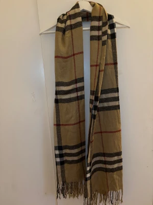 Rutig halsduk i beige | klassisk | höst/vinter - Klassisk rutig halsduk i beige, svart och rött. Mjuk och varm, passar perfekt till höst- och vinterjackor. Tidlös stil som funkar till både vardag och jobb. Mycket Fint skick, UNISEX ⚡ Skickas snabbt ⚡