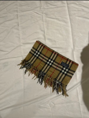 Burberry scarf/halsduk-klassisk - Burberry Scarf  Size: No Size  Condition: Very Good  This Burberry scarf features the classic check pattern and is made from high-quality fabric. It shows minimal signs of wear and is perfect for adding a stylish touch to any outfit.  ✅ Authenticity Guaranteed  📩 Open to offers - message if you have questions.  🚚 Shipping - same-day dispatch or within 24 hours.  #Burberry #Scarf #DesignerFashion #LuxuryAccessories #BritishStyle #CheckPattern #VeryGoodCondition #AuthenticBurberry #FashionEssentia