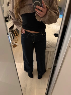 Mörkblå low waist jeans från Motel Rocks  - Säljer ett par mörkblå jeans från Motel rocks med breda ben och låg midja. De är aldrig använda och har prislappen kvar. Orginalpris är 833 kr, storlek W30/ L32