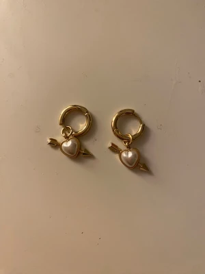 Guldörhängen med hjärta från PINK - Säljer ett par örhängen från Pink! Ej använda, fick som present men har ej använt dom efter köpet. Kommer med påsen! Skriv om du har frågor😽!köpte ett örhänge åt gången för 129kr st!