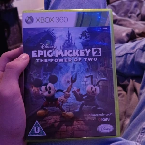 Epic Mickey 2: The Power of Two (Xbox 360) - Epic Mickey 2: The Power of Two till Xbox 360. Komplett med originalfodral och skiva i fint skick. Ett co-op äventyr där du spelar som Mickey och Oswald i en magisk Disney-värld. Inga synliga repor eller skador på fodral eller skiva.