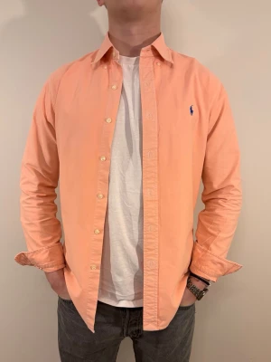 Roda Ralph Lauren skjorta - En stilren skjorta från Ralph Lauren Second hand men i väldigt fint skick ✨ Tvättad och struken – redo att användas direkt.  Perfekt för sommaren/våren, funkar både uppklätt och casual. Inga defekter och slim fit.  Storlek 👔: M Nypris 💰: ca 1 300 kr 