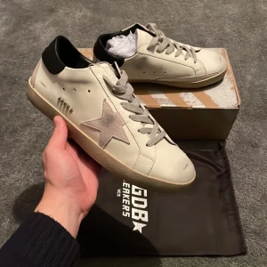 Golden Goose Skor - Säljer ett par riktig feta Golden Goose i strl 41.               ‼️HELT NYA‼️                                                                     Skorna är i helt nytt skick och har aldrig prövats.           NYTT PRIS: 5995 kr  MITT PRIS: 2499 kr.                         Allting OG följer med                                          Tveka inte på att höra av dig vid minsta lilla fundering!💛
