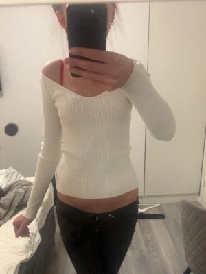 Vit ribbad långärmad topp - Säljer en vit ribbad topp med lång ärm och v-ringad hals. Från hm i storlek xs