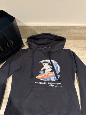 Polo hoodie  - En stilren polo hoodie, köpt för ett tag sen i polo butiken i MOS. Perfekt för dig som söker en skön men fin tröja till vardagen. Storleken är M men jag skulle säga att det är storlek S. Självklart öppen för diskussioner gällande pris.