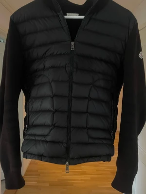 Moncler Cardigan - Säljer en Moncler Cardigan i storlek M. Efter tid så passar den inte längre så det är därför jag säljer den. Väldigt bra skick och trendig jacka. Klockrent plagg. Passar till nästan alla outfits! Finns ej luva, endast seriösa köpare!
