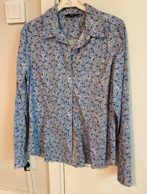 Småblommig skjorta Ellos - Småblommig skjorta från Ellos. Mycket fint skick. Vit,ljusblå,blå. 