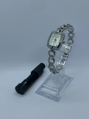 Silverfärgade damklocka med quartz urverk  - KÖP 2 FÅ 1 PRESENT   Elegant damklocka från Chiste med quartz urverk. Klockan har ett silverfärgat armband med dekorativa detaljer.  ✅Frakt inom 24 timmar🚚. ✅Kvalitets testad⚜️. ✅Säkert paketerat📦. ✅Nytt Batteri 🔋. 🟠Köp 3 saker få en procent på köpet 🎁. Klockhållaren kommer inte med.