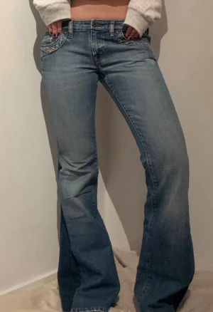 Diesel jeans - Snygga ljusblå bootcut jeans från diesel och har broderade detaljer på bakfickorna. Xs/S Midjemått rakt över: 39 cm Innerbenslängd: 80 cm