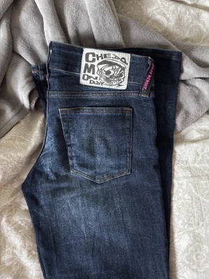 Cheap Monday mörkblå bootcut jeans - Säljer ett par snygga mörkblå jeans från Cheap Monday med bootcut passform. Jeansen har klassisk femficksdesign, låg midja och coolt Cheap Monday-märke med döskalle på bakfickan. Materialet är jeans med lätt stretch och slitningar framtill 🥰