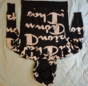 Champion Reverse Weave Hoodie - Snygg svart Champion Reverse Weave Hoodie med vitt tryck med Champion loggan på fram och baksida. Använd flertalet gånger men i bra skick tack vare den högkvalitativa Reverse Weave modellen. 