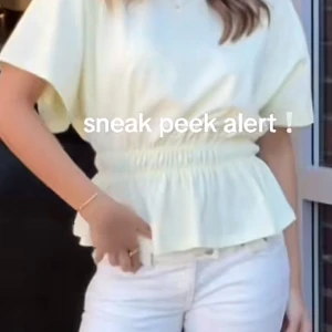 Vit blus med resår i midjan - Säljer en vit blus med korta ärmar och rund hals. Toppen har en markerad resår i midjan som ger en snygg volang-effekt nedtill. Tillverkad i mjuk bomull, perfekt för en fräsch och stilren look.PRIS KAN DISKUTERAS