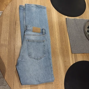 Weekday ljusblå straight jeans 25/32 - Säljer ett par ljusblå jeans från Weekday i modellen Twig Mid Straight. Klassisk femficksdesign, raka ben och mellanblå tvätt. Perfekta för dig som gillar en clean och enkel look. Storlek 25/32.