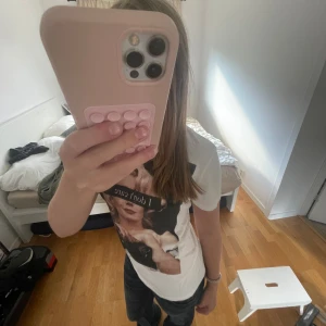 Vit t-shirt med tryck och text - Säljer en vit t-shirt med ett stort tryck framtill av Marilyn Monroe och texten 'I don't care' över ögonen. T-shirten har korta ärmar och en klassisk passform. Perfekt för dig som gillar statement-plagg och coola prints💓 Aldrig använd endast testad!!