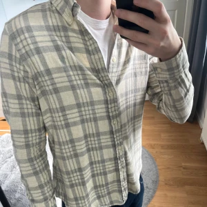 Ralph Lauren skjorta  - Skjorta i tunn flanell, från Ralp Lauren, storlek M, jag är 180, grå/vit färg, någon typ av färg på labeln men ingen märkvärdigt, skriv vid frågor!