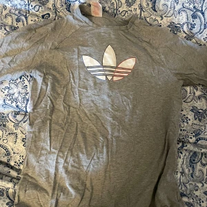 T-shirt - Grå t-shirt med adidas tryck. Lapparna är bortklippta men den är från adidas. (Se lilla symbolen på bild) Sparsamt använd. Storlek 15-16y 176 men passar mig som har S. Tvättar allt innan, skriv för mer bilder eller om du har några frågor.💞