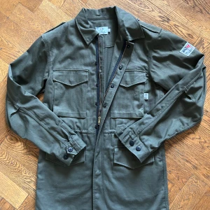 Olivgrön overshirt från Tyndale - Jag säljer en rejäl olivgrön jacka från Tyndale. Storlek S, men passar nästan som M Jackan är sparsamt använd utan några tecken på användning, så gott som ny! Nypriset på jackan är 3599kr❌ men jag säljer den för endast 799kr ✅Plagget är i högkvallitet och producerad i tjock bomull (100%) vilket gör att den är perfekt till kyligare höstdagar och även till vintern.  Självklart kan pris diskuteras! Hör av dig vid minsta fundering!