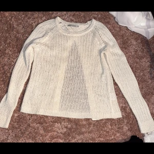 Beige stickad kofta från Mira & Mira - Snygg beige stickad kofta från Mira & Mira i storlek M. Koftan har ett öppet framstycke och är gjord i ett luftigt stickat material med långärmad passform. Perfekt att slänga över en topp för en chill och stilren look.