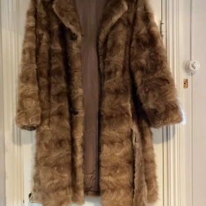 Pälskappa - Äldre päls. Har ett hack i armen och en knapp saknas