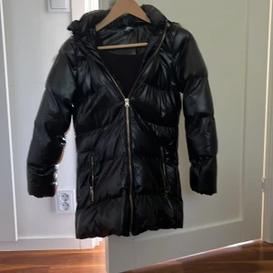 Svart lång pufferjacka med fuskpäls - Snygg svart pufferjacka är inte sönder någon stans skön håller dig varm