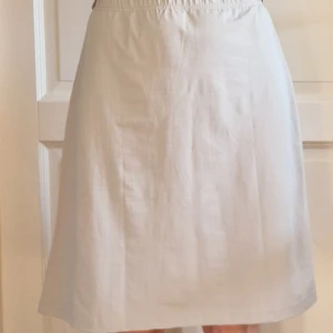 Gråvit kjol från DEEP - Snygg ljust grå kjol, som går mot vit, från DEEP med elastisk midja och fint fall. Oanvänd.