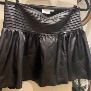 Svart skinnkjol från Gina Tricot - Snygg svart kortkjol från Gina Tricot i skinnimitation. 💕💕💕