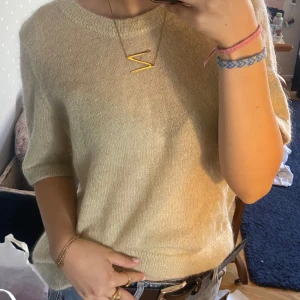 Beige stickad tröja från Stockh LM - Supermjuk och fluffig beige stickad tröja från Stockh LM. Tröjan har korta ärmar, rund halsringning och en lätt glansig finish som ger en lyxig känsla. Perfekt att styla med jeans eller kjol för en chill och trendig look❤️aldrig använd!!