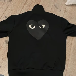 Svart jacka Comme des Garçons Play - Svart jacka med zipup. Bra skick men en liten skråma som jag tagit bild på. Köpt i Japan 2019. 