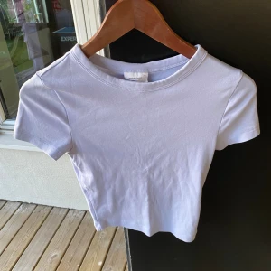 Ljusblå croppad topp från Gina Tricot XS - Säljer en basic ljusblå croppad topp från Gina Tricot, basically basics-kollektionen. T-shirten har rund halsringning och korta ärmar. Perfekt att matcha med jeans eller kjol för en clean look.
