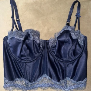 Mörkblå korsett från Victoria's Secret - Vacker mörkblå korsett från Victoria's Secret med justerbara axelband och spetsdetaljer längs kanterna, spets både upptill och nedtill. ödrig använd då den är för stor tyvärr