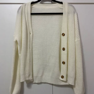 Vit stickad kofta / cardigan med knappar - Mysig vit stickad kofta / cardigan med stora bruna knappar framtill ! Aldrig använt då den inte kommit till användning, storlek XS ✨ Pris går att diskuteras🤗