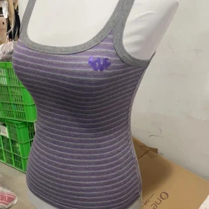 Randig lila linnetopp från Intimissimi - Säljer en snygg randig linnetopp från Intimissimi i lila och grå toner. Toppen har smala axelband, grå kant runt hals och ärmhål samt ett litet lila tryck på bröstet. Materialet är mjukt och stretchigt med bomull och lite glittrig effekt i ränderna.