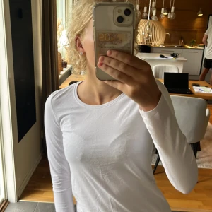 Vit långärmad topp i bomull - Säljer en enkel och fräsch vit långärmad topp med rund hals. Modellen är figurnära och passar perfekt till jeans eller kjol. Materialet är mjukt och skönt bomull. Väldig skön och aldrig använd! Det står på tröjan att det är storlek 158/164 men passar mig som har XS! 