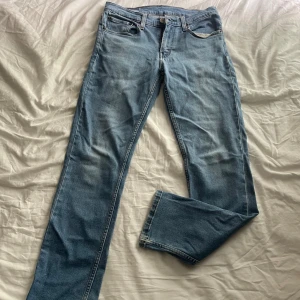 Levi's 511 ljusblå jeans W31 L32 - Snygga ljusblå Levi's 511 jeans med klassisk femficksdesign och normal passform. Jeansen har raka ben och är tillverkade i mjukt denimtyg av bomull. Perfekta för dig som gillar en stilren och avslappnad look.