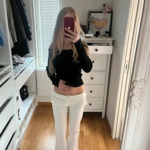 Vita lågmidjade kostymbyxor - Säljer ett par vita kostymbyxor med låg midja och raka ben. Byxorna har klassiska fickor och bälteshällor, perfekt för en clean och trendig look. Snygg passform som ger en stilren siluett.