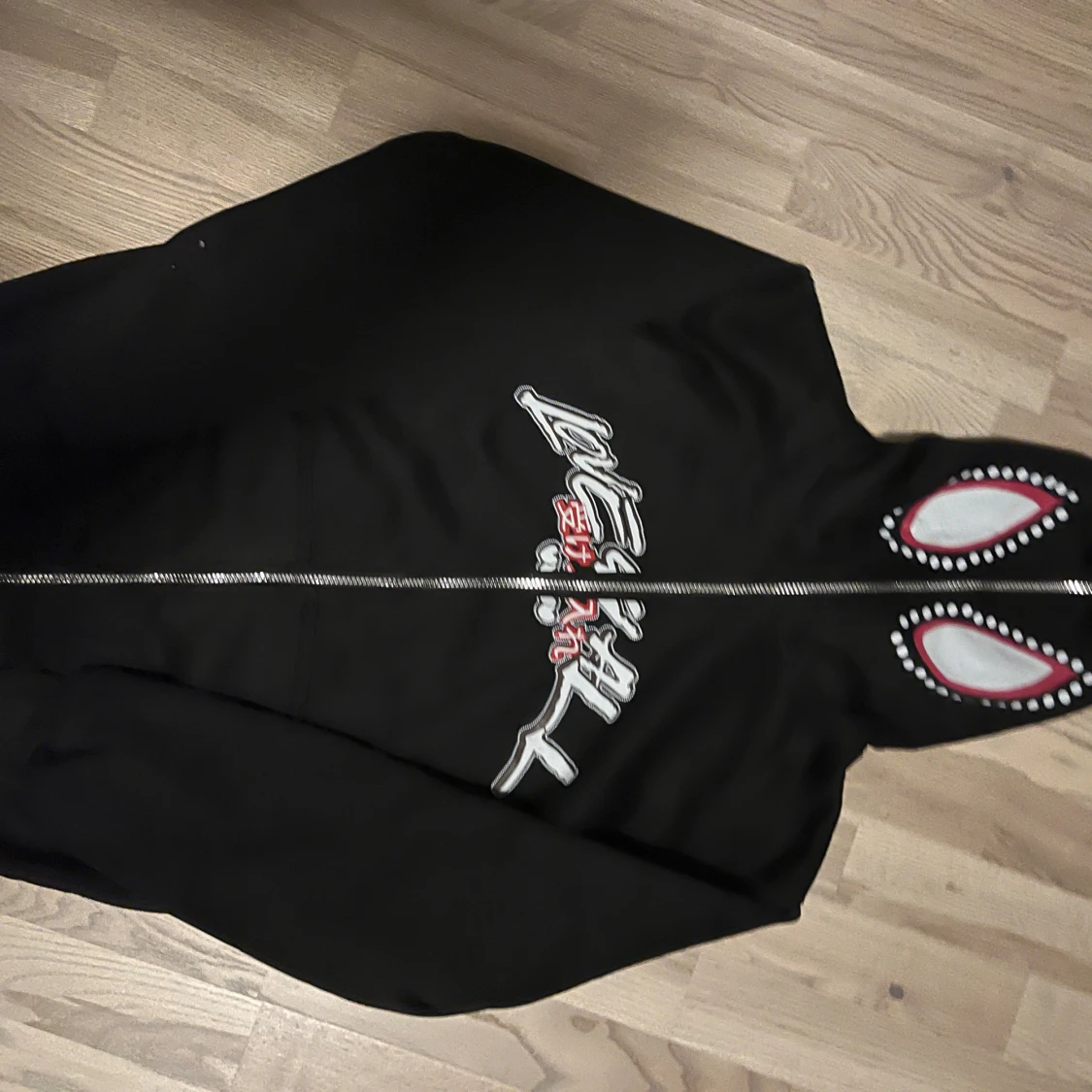 Svart hoodie med ögon på huvan