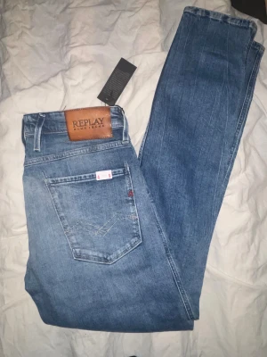 Replay slim fit ljusblå jeans - Snygga ljusblå jeans från Replay med slim fit-passform. Klassisk femficksmodell med Replay-läderpatch bak och diskreta slitningar framtill. Jeansen är tillverkade i mjukt denimtyg och har en modern, smal siluett som sitter snyggt på benen.               Helt nya oanvända jeans Orginal pris: 1300