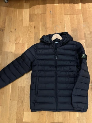 Stone Island jacka - Dunjacka, pufferjacka riktigt skön, använd 3-5 gånger så nästan i helt ny skick, färg = mörkblå, riktigt fin material. Storlek M kan kanske passa S. 1;1