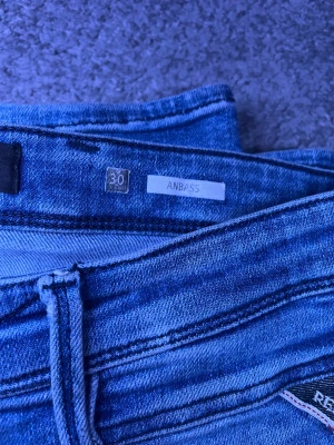 Replay Anbass - Snygga Replay Anbass  i blå denim. Stretchiga, bekväma och en av de mest eftertraktade modellerna från Replay.  Skick: ✔ Bra skick ✔ Stretch kvar ✔ Inga hål eller fläckar  Detaljer: • Modell: Anbass • Storlek: W30 L30 • Färg: Blå • Hyperflex – superstretch