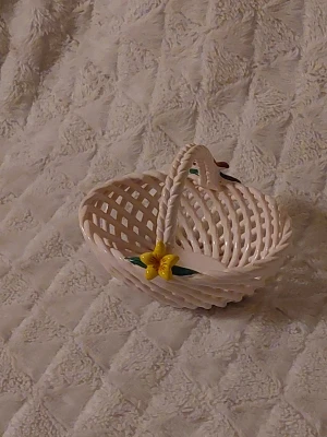 Vit flätad keramik påskskål med blommor - Söt keramik påskdkål i vit flätad design med två färgglada blommor, en gul och en röd, på handtaget. har oval form och öppet mönster, perfekt för dig som gillar unika detaljer. Blommorna har gröna blad och ger en fräsch vibe.