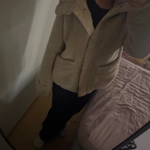 Beige teddyjacka från Pernilla Wahlgren  - Säljer en beige teddyjacka med fluffigt material. Jackan är perfekt för dig som gillar mysiga och trendiga jackor med oversized känsla. Strl är S men passar helt klart M också